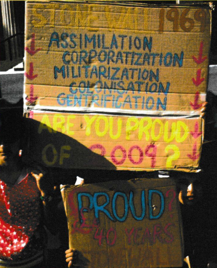 Page 2 of PRIDE zine, shows photograph of a protest with signs saying 'Stonewall 1969 Assimilation Corporatisation Militarisation Colonisation Gentrification', 'Are you Proud of 2009?' and 'Proud 40 years Stonewall'